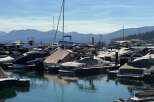 Experience the ultimate waterfront lifestyle with this stunning marina featuring a wide array of boats docked under a clear blue sky.