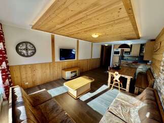 Experience rustic charm in this inviting living space, featuring warm wooden paneling and a cozy seating area perfect for relaxation.