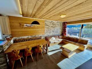 Experience rustic charm in this inviting living and dining area, featuring a warm wooden ceiling and accent walls.