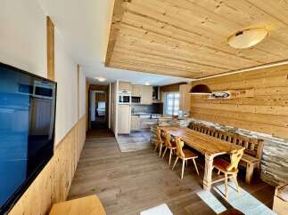 Experience rustic charm in this beautifully appointed dining area, featuring a solid wood table and benches perfect for family gatherings.
