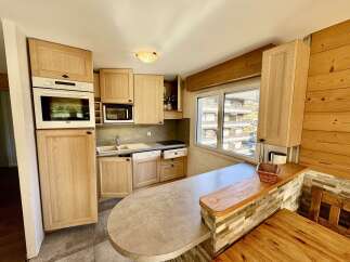 Discover this charming kitchen featuring light wood cabinetry and a sleek countertop.