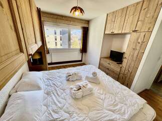 Experience ultimate comfort in this charming bedroom, featuring a plush queen-size bed adorned with crisp white linens and fluffy pillows.