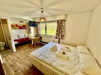 Experience comfort and convenience in this charming room, featuring a plush bed adorned with fresh white linens and fluffy towels.