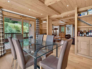 Experience luxurious mountain living in this stunning dining area, featuring a sleek glass-top dining table surrounded by comfortable chairs.