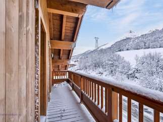 Experience the charm of a winter wonderland from this charming wooden balcony.