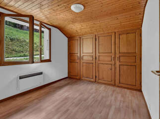 Discover this charming room featuring a beautiful wooden ceiling and built-in wooden wardrobes, offering ample storage space.