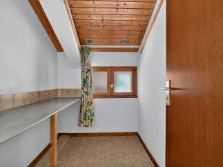 Discover this charming room featuring a practical countertop and a cozy wooden ceiling.