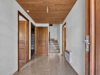 Step into this charming hallway featuring a warm wooden ceiling and tiled flooring, creating an inviting atmosphere.