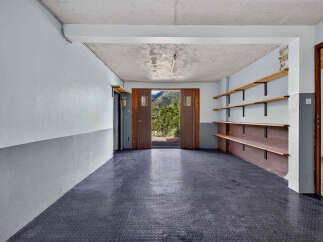 Discover this versatile space featuring a durable, textured dark floor and ample shelving for storage.