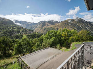 Experience breathtaking mountain vistas from this property, featuring a charming village nestled in the valley below.