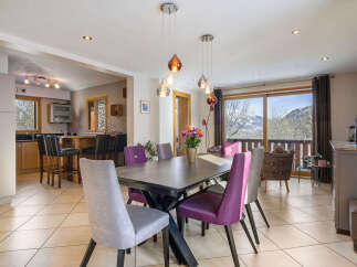 Experience breathtaking mountain views from this stunning dining area, featuring a spacious table perfect for family gatherings.