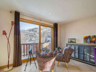 Experience breathtaking mountain views from this charming living area, featuring a large sliding glass door that opens to a private balcony.