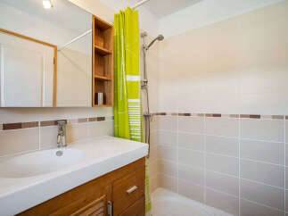 This bathroom features a modern vanity with a sleek white sink and a wooden cabinet below.