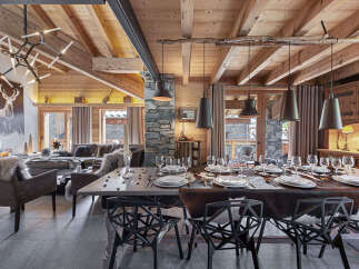 Experience luxury mountain living in this stunning chalet, featuring a grand dining area perfect for entertaining.
