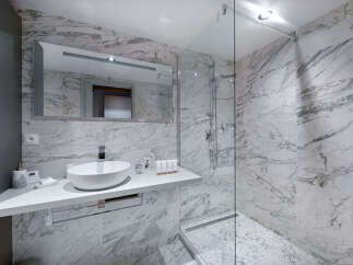 Experience modern luxury in this stunning bathroom featuring elegant marble finishes throughout.