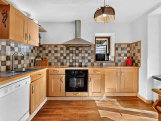 Discover this charming kitchen featuring warm wooden cabinetry and a classic checkered backsplash.