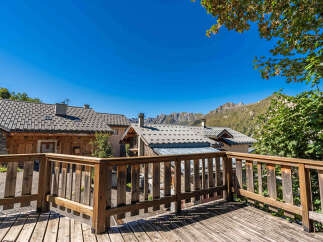Experience breathtaking mountain views from this charming wooden deck, perfect for enjoying the crisp alpine air.