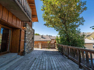 Experience the charm of mountain living with this stunning wooden chalet, featuring a spacious deck perfect for enjoying the breathtaking alpine views.