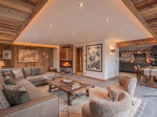 Experience luxurious mountain living in this stunning chalet-style living room, featuring a cozy fireplace and a spacious sectional sofa perfect for gathering.