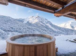 Experience ultimate relaxation with this stunning outdoor hot tub, perfectly situated to offer breathtaking views of snow-capped mountains.