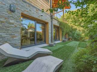 Experience modern living with this stunning property featuring sleek stone and wood exterior finishes.