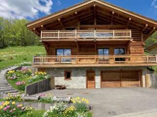 Experience luxury mountain living in this stunning wooden chalet, featuring multiple balconies with breathtaking views and a stone-clad lower level.