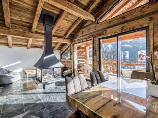 Experience luxurious mountain living in this stunning chalet featuring a modern fireplace and expansive glass doors that open to breathtaking alpine views.