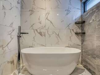 Experience ultimate relaxation in this luxurious bathroom, featuring a stunning freestanding bathtub as the centerpiece.