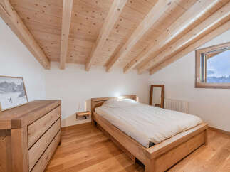 Experience cozy mountain living in this charming bedroom featuring a natural wood aesthetic.