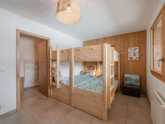 This charming bedroom features a sturdy wooden bunk bed, perfect for families or guests.