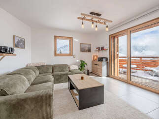 Experience breathtaking mountain views from this modern living room, featuring a plush sectional sofa and a stylish coffee table.