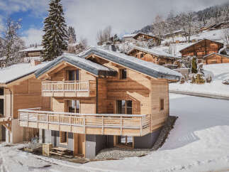 Experience the charm of alpine living in this stunning wooden chalet, nestled on a picturesque snowy hillside.