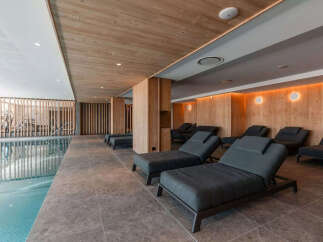 Experience ultimate relaxation in this luxurious spa area, featuring a serene indoor swimming pool and a dedicated lounge with comfortable chaise lounges.
