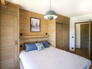 Experience cozy mountain living in this charming bedroom featuring warm wood paneling throughout.