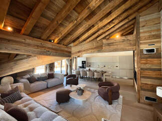 Experience luxurious mountain living in this stunning chalet, featuring a grand open-plan living area with a vaulted wooden beam ceiling and a modern, fully-equipped kitchen.