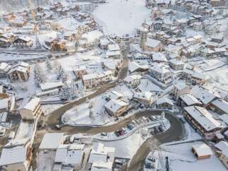 Experience the charm of a snow-covered alpine village with this stunning aerial view.