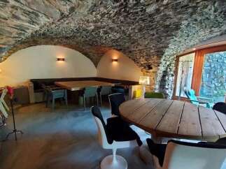 Experience rustic charm in this unique dining space featuring a stone-arched ceiling and cozy booth seating.