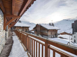 Experience the charm of alpine living with this stunning property, featuring traditional wooden architecture set against a breathtaking snowy mountain backdrop.