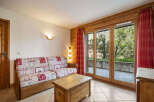 Experience cozy living in this charming room featuring a rustic wooden sofa with a patterned quilt-style upholstery.