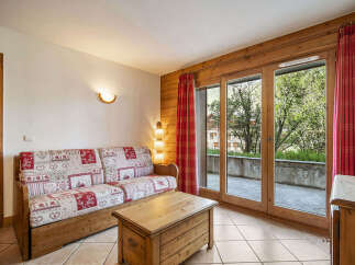 Experience cozy living in this charming room featuring a rustic wooden sofa with a patterned quilt-style upholstery.