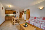 This charming living space features a cozy dining area with a wooden table and chairs, perfect for family meals.