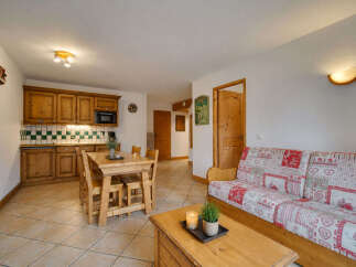 This charming living space features a cozy dining area with a wooden table and chairs, perfect for family meals.