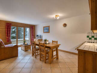 Experience cozy living in this charming mountain retreat, featuring a warm wooden interior and a comfortable sofa perfect for relaxing after a day on the slopes.