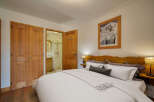 This charming bedroom features a cozy queen-size bed with crisp white linens and a decorative throw blanket.