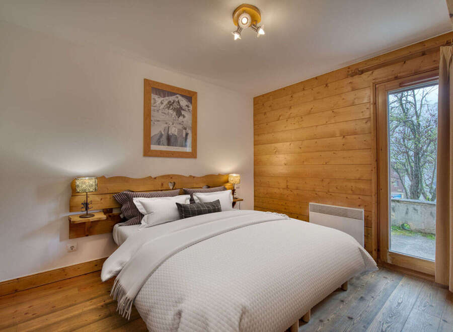 Experience cozy mountain living in this charming bedroom featuring a rustic wooden headboard and accent wall.