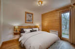 Experience cozy mountain living in this charming bedroom featuring a rustic wooden headboard and accent wall.
