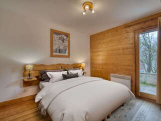 Experience cozy mountain living in this charming bedroom featuring a rustic wooden headboard and accent wall.