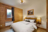 Experience cozy mountain living in this charming bedroom, featuring warm wood paneling and a comfortable queen-sized bed.