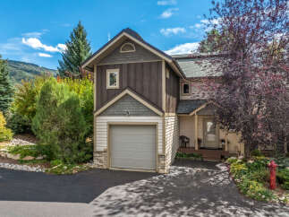 Charming mountain home featuring a two-car garage and a welcoming front porch.