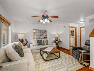 Step into this inviting living room, featuring a plush sectional sofa adorned with decorative pillows and a cozy throw.